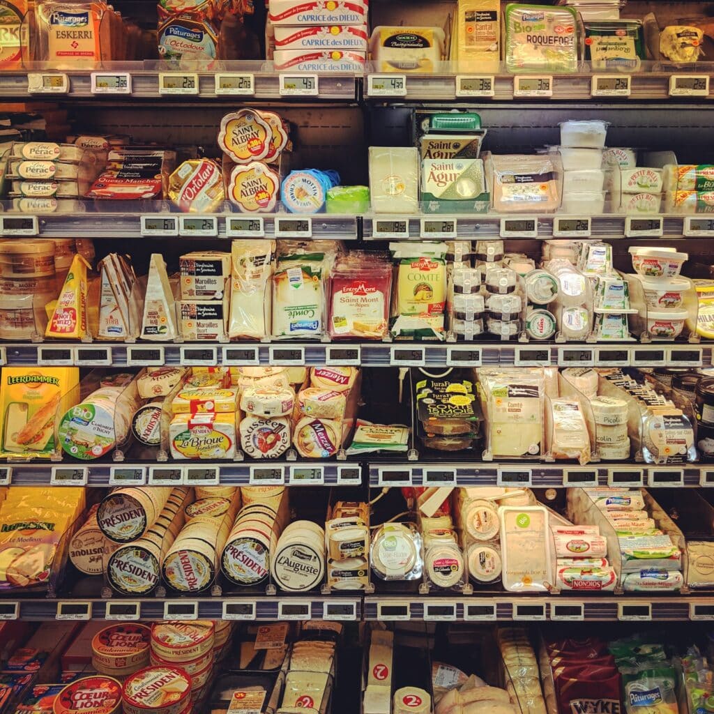 Four shelves in a grocery display filled with cheese. Basket analysis can identify what items are purchased together to optimize product and store layouts.